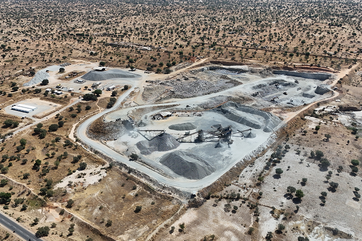 High-altitude aerial view of an open-pit rock quarry with an aggregate processing plant surrounded by arid countryside.